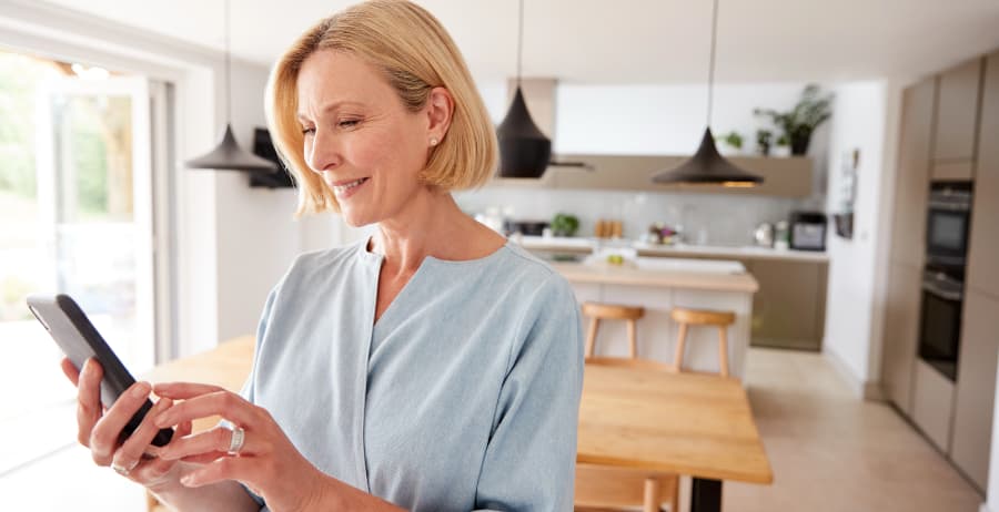 Homeowner holding a smartphone in a modern home